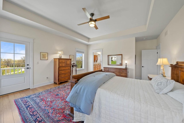 1387 Wilmington Way Unit 3-34, Lake Geneva, WI 53147 - bedroom featuring a tray ceiling, light wood-style flooring, a ceiling fan, baseboards, and ensuite bathroom