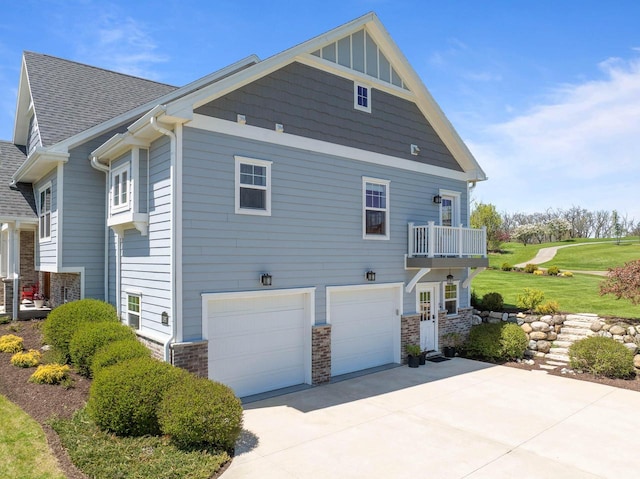 1387 Wilmington Way Unit 3-34, Lake Geneva, WI 53147 - view of side of property with driveway, a garage, a yard, stone siding, and a balcony