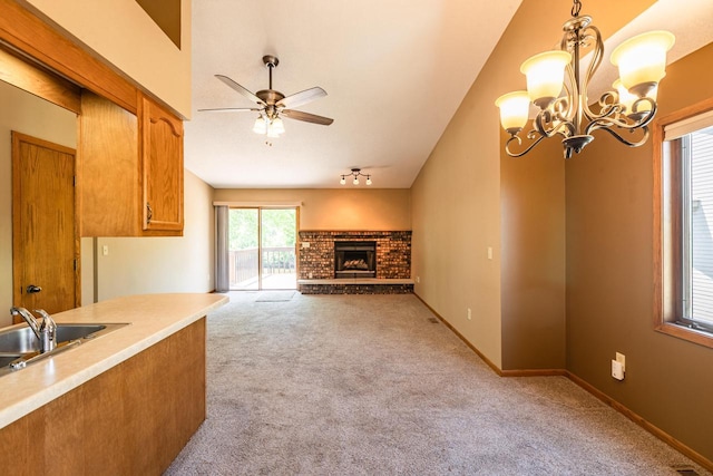 unfurnished living room featuring a sink, light carpet, ceiling fan, a brick fireplace, and lofted ceiling