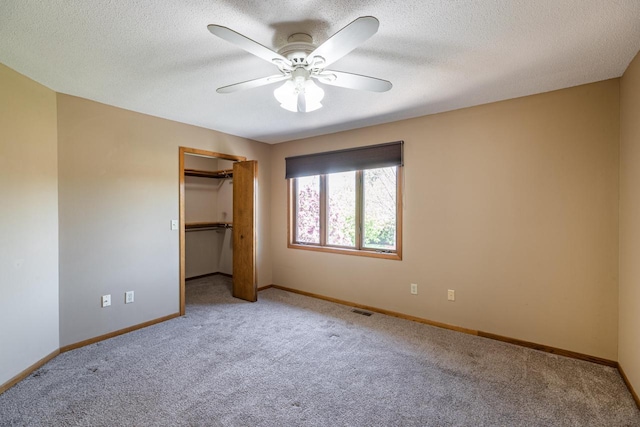 unfurnished bedroom featuring carpet flooring, baseboards, a ceiling fan, and a textured ceiling