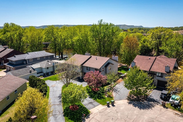 aerial perspective of suburban area featuring a mountainous background and a heavily wooded area