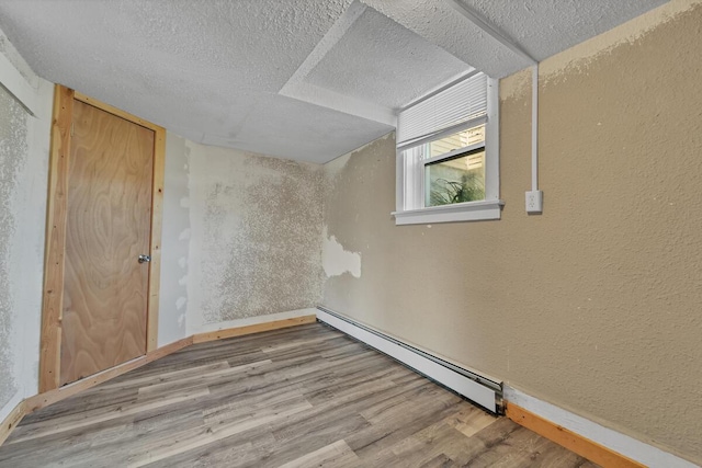 2936 S 9th Pl, Milwaukee, WI 53215 - bonus room featuring a baseboard radiator, a textured wall, wood finished floors, baseboards, and a textured ceiling