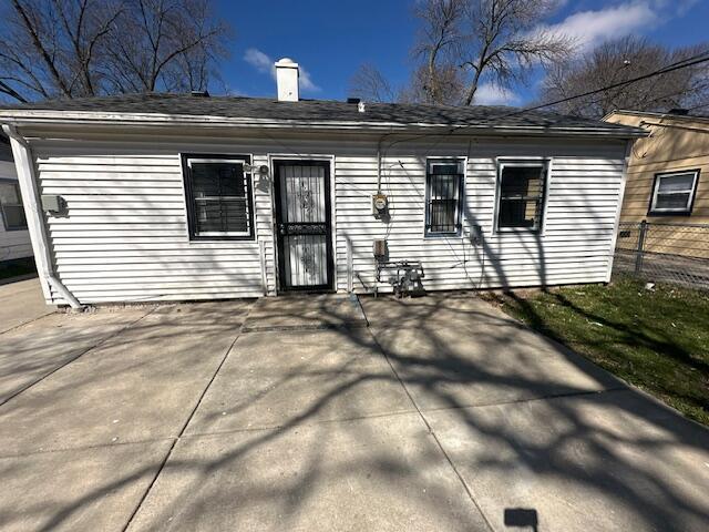 back of house featuring a patio area, fence, and a chimney