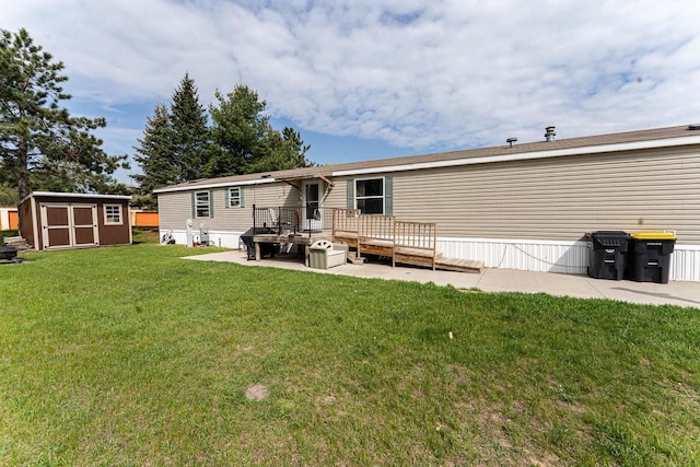 277 James St, Tomah, WI 54660 - rear view of house featuring a storage shed, an outbuilding, a wooden deck, a yard, and a patio area