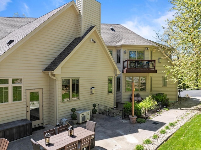 1521 Geneva Club Dr Unit 18-05, Lake Geneva, WI 53147 - back of house featuring a patio area, a balcony, a chimney, a shingled roof, and an outdoor hangout area