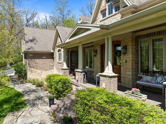 1521 Geneva Club Dr Unit 18-05, Lake Geneva, WI 53147 - view of exterior entry featuring covered porch, stone siding, a shingled roof, and brick siding
