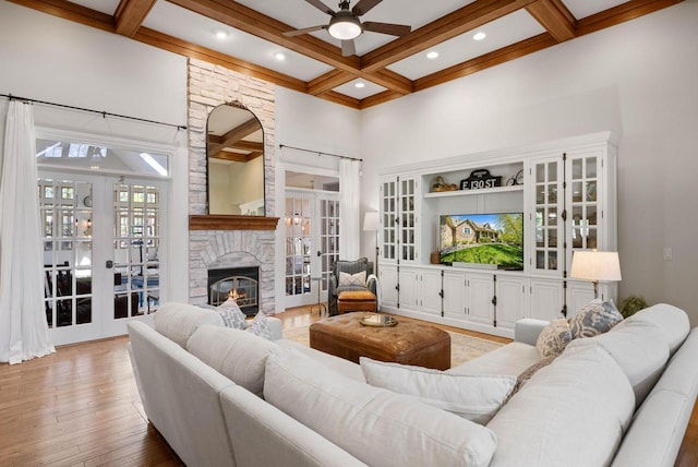 1521 Geneva Club Dr Unit 18-05, Lake Geneva, WI 53147 - living room featuring coffered ceiling, ceiling fan, french doors, a stone fireplace, and beamed ceiling
