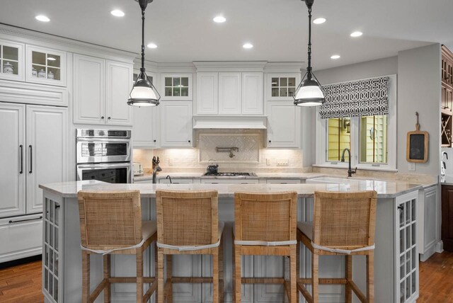 1521 Geneva Club Dr Unit 18-05, Lake Geneva, WI 53147 - kitchen with a sink, appliances with stainless steel finishes, white cabinets, light stone countertops, and glass insert cabinets