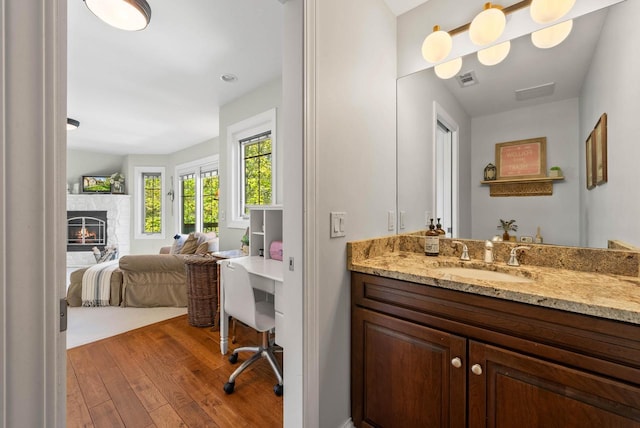 1521 Geneva Club Dr Unit 18-05, Lake Geneva, WI 53147 - ensuite bathroom featuring wood-type flooring, a lit fireplace, and vanity