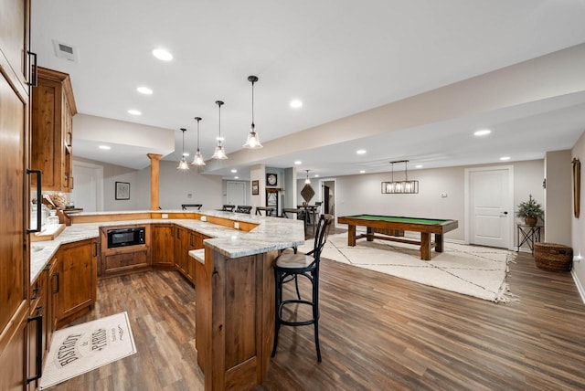 1521 Geneva Club Dr Unit 18-05, Lake Geneva, WI 53147 - kitchen featuring dark wood-style flooring, billiards, black microwave, brown cabinets, and a kitchen bar