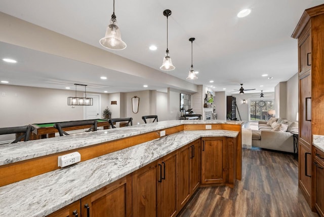 1521 Geneva Club Dr Unit 18-05, Lake Geneva, WI 53147 - kitchen with open floor plan, dark wood finished floors, hanging light fixtures, recessed lighting, and light stone counters