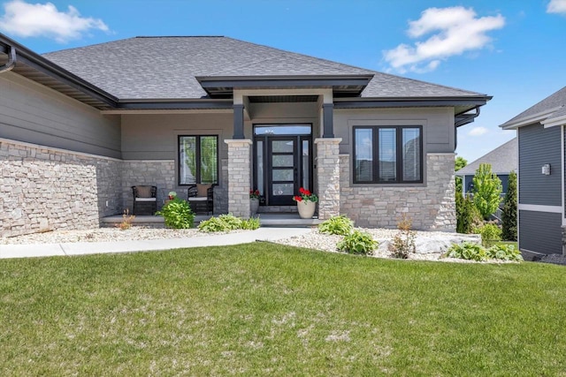 802 Lynn St, Waunakee, WI 53597 - view of front of home with stone siding, a shingled roof, a front yard, and covered porch