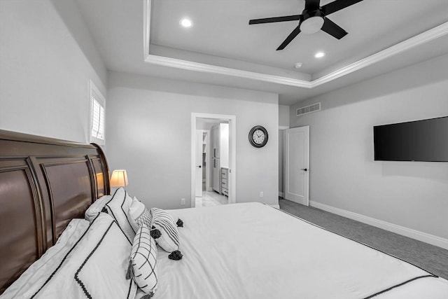 802 Lynn St, Waunakee, WI 53597 - carpeted bedroom with a tray ceiling, recessed lighting, baseboards, ensuite bathroom, and a ceiling fan