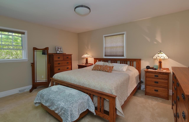 bedroom featuring light colored carpet and baseboards