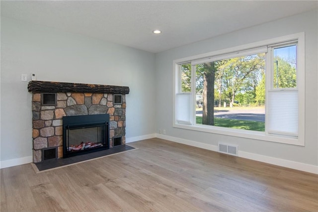 504 Wisconsin Ave, Frederic, WI 54837 - unfurnished living room featuring baseboards, a stone fireplace, wood finished floors, and recessed lighting