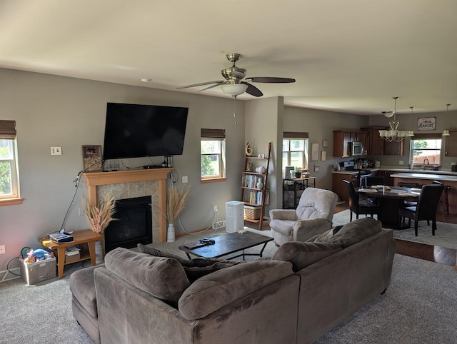 4374 Bent Grass Ct, Windsor, WI 53598 - living room with a tile fireplace, ceiling fan, a chandelier, and baseboards
