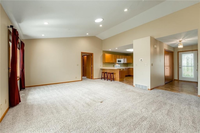 1153 Weather Ridge Rd, Chippewa Falls, WI 54729 - unfurnished living room with lofted ceiling, baseboards, light colored carpet, and recessed lighting