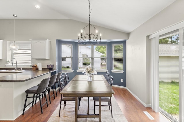 1959 S Cross Creek Cir, De Pere, WI 54115 - dining room with lofted ceiling, healthy amount of natural light, light wood-style floors, a chandelier, and baseboards