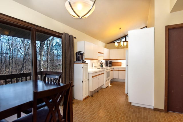 1031 N Osborne Blvd, Racine, WI 53405 - kitchen featuring white appliances, a chandelier, white cabinets, light countertops, and lofted ceiling