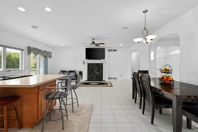 8705 Nelson Xing, Verona, WI 53593 - dining space with a ceiling fan, arched walkways, a premium fireplace, light tile patterned flooring, and recessed lighting