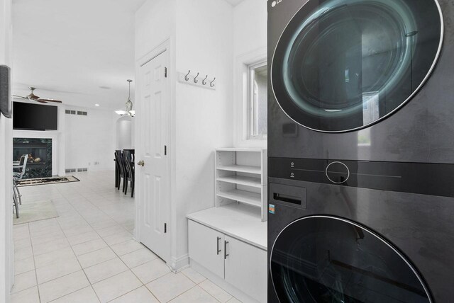8705 Nelson Xing, Verona, WI 53593 - washroom with stacked washer / drying machine, ceiling fan, light tile patterned floors, a fireplace, and baseboards
