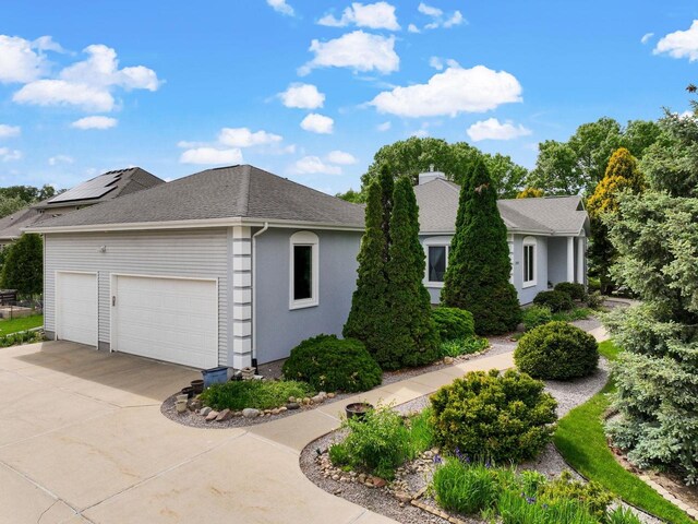 8705 Nelson Xing, Verona, WI 53593 - view of home's exterior with driveway, roof with shingles, a garage, and stucco siding