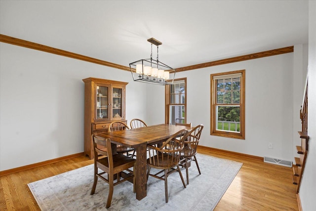 N39W32890 High Hill Ct, Nashotah, WI 53058 - dining room featuring a chandelier, baseboards, light wood-type flooring, ornamental molding, and stairs