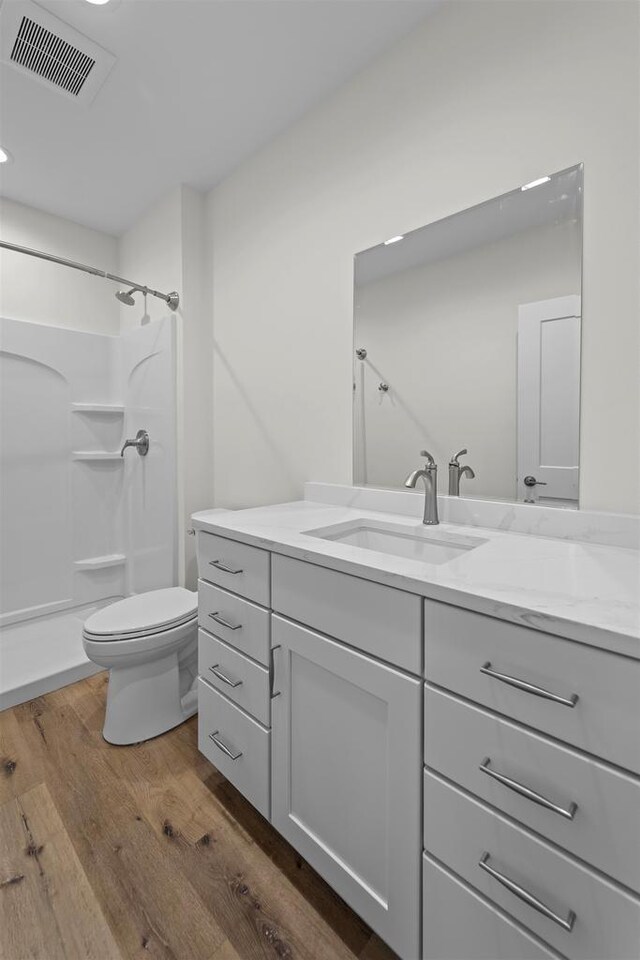 1407 Ridgetrail Dr, Cross Plains, WI 53528 - bathroom featuring vanity, wood finished floors, a shower, toilet, and recessed lighting