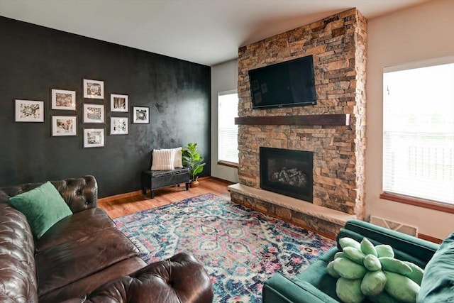6972 Heirloom Dr, Deforest, WI 53532 - living area featuring wood finished floors, plenty of natural light, an accent wall, and a fireplace