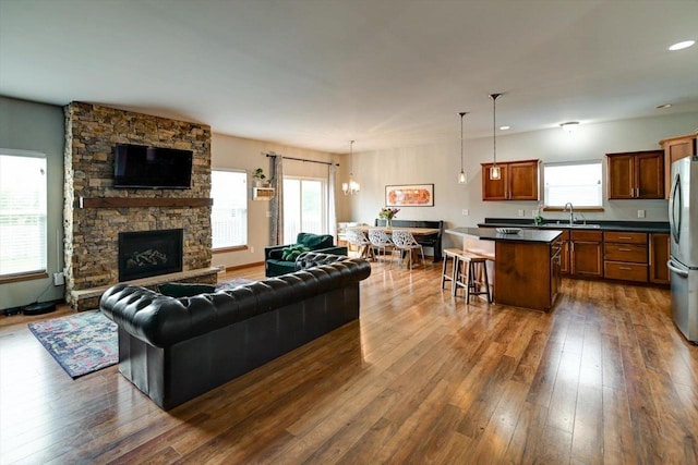 6972 Heirloom Dr, Deforest, WI 53532 - living room with healthy amount of natural light, dark wood-style flooring, a stone fireplace, and recessed lighting