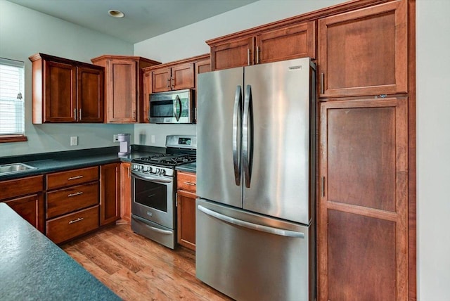 6972 Heirloom Dr, Deforest, WI 53532 - kitchen with appliances with stainless steel finishes, light wood-style flooring, dark countertops, recessed lighting, and a sink