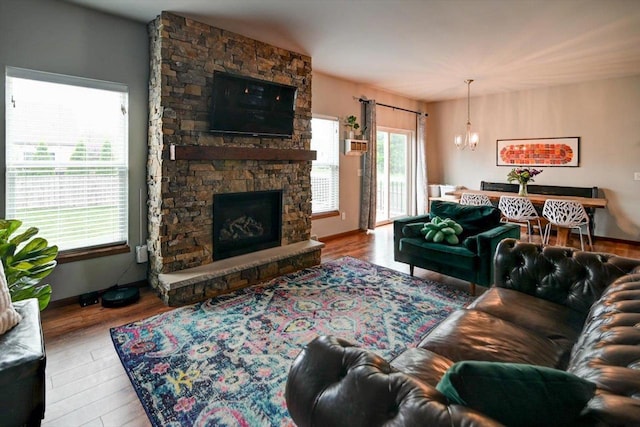 6972 Heirloom Dr, Deforest, WI 53532 - living area featuring a chandelier, a fireplace, wood finished floors, and baseboards