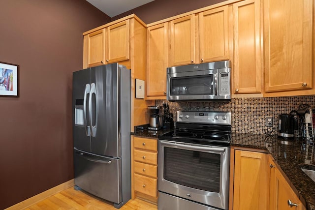 1325 N Van Buren St Unit 308, Milwaukee, WI 53202 - kitchen with stainless steel appliances, tasteful backsplash, dark stone countertops, and light wood-type flooring