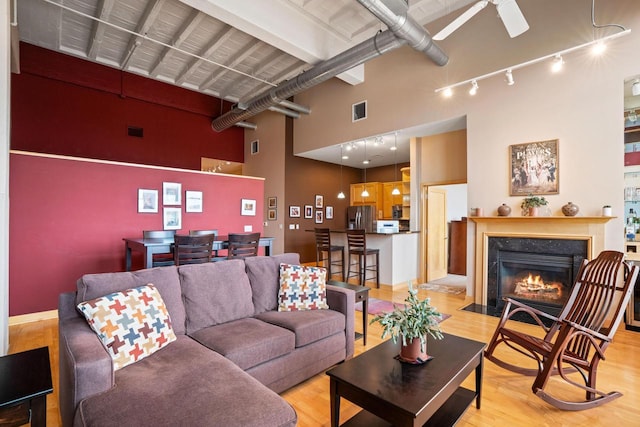 1325 N Van Buren St Unit 308, Milwaukee, WI 53202 - living room with a high ceiling, light wood-style flooring, rail lighting, a high end fireplace, and a desk