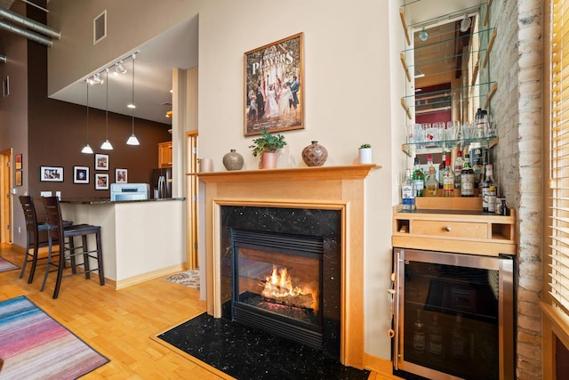 1325 N Van Buren St Unit 308, Milwaukee, WI 53202 - living room featuring track lighting, a high end fireplace, wood finished floors, and wine cooler