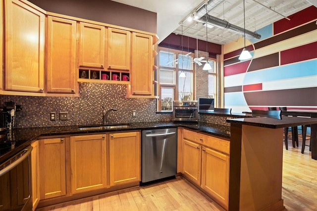 1325 N Van Buren St Unit 308, Milwaukee, WI 53202 - kitchen with a sink, stainless steel appliances, a peninsula, light wood-style floors, and backsplash