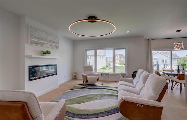 6612 Vista Vly, Windsor, WI 53598 - living area featuring a glass covered fireplace, recessed lighting, light wood-style floors, and baseboards
