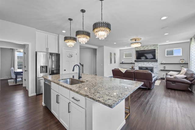 432 Tawny Elm Pkwy, Verona, WI 53593 - kitchen featuring a sink, appliances with stainless steel finishes, dark wood-style flooring, white cabinets, and a fireplace