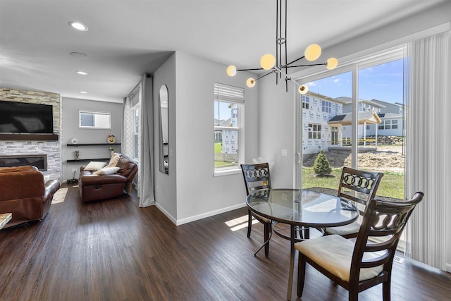432 Tawny Elm Pkwy, Verona, WI 53593 - dining room featuring baseboards, dark wood finished floors, a stone fireplace, recessed lighting, and a chandelier