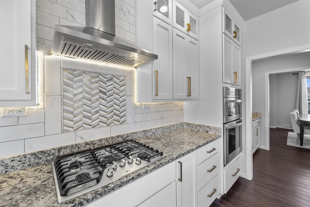 432 Tawny Elm Pkwy, Verona, WI 53593 - kitchen featuring wall chimney exhaust hood, stainless steel appliances, backsplash, glass insert cabinets, and light stone counters