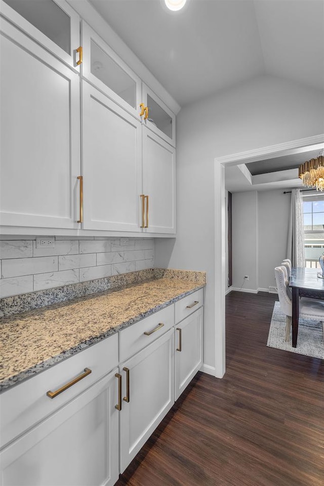 432 Tawny Elm Pkwy, Verona, WI 53593 - kitchen featuring dark wood-style flooring, baseboards, tasteful backsplash, light stone countertops, and glass insert cabinets