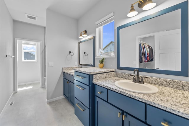 432 Tawny Elm Pkwy, Verona, WI 53593 - bathroom featuring two vanities, baseboards, and a spacious closet