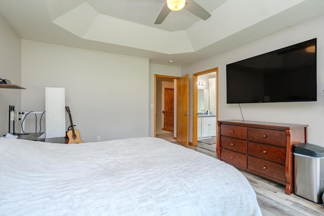 175545 Willow Ln, Ringle, WI 54440 - bedroom featuring a tray ceiling, light wood-type flooring, ensuite bathroom, and ceiling fan