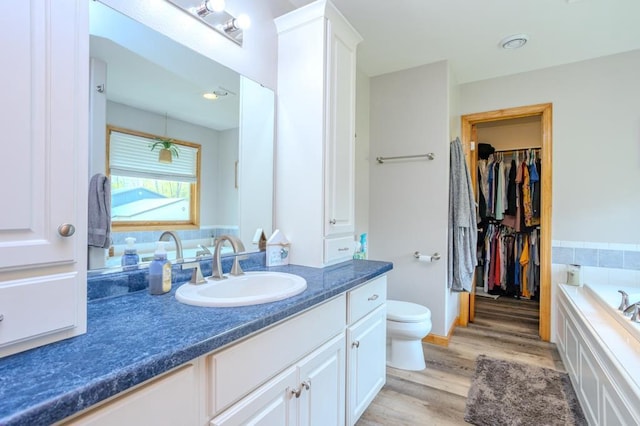 175545 Willow Ln, Ringle, WI 54440 - bathroom with wood finished floors, vanity, a garden tub, toilet, and a walk in closet