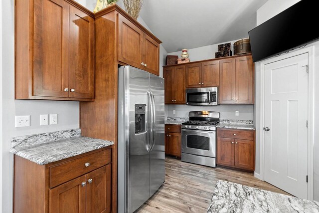 1397 Lear Ln, De Pere, WI 54115 - kitchen with appliances with stainless steel finishes, light wood-style flooring, brown cabinetry, and light stone countertops