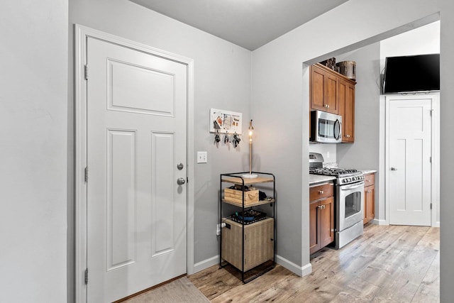 1397 Lear Ln, De Pere, WI 54115 - kitchen featuring stainless steel appliances, light wood-style floors, brown cabinetry, and light countertops