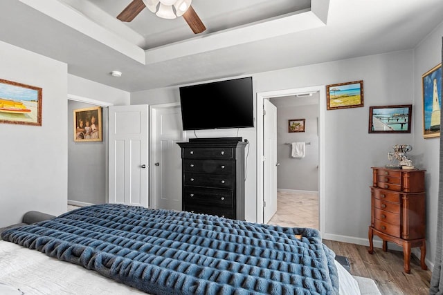 1397 Lear Ln, De Pere, WI 54115 - bedroom featuring a tray ceiling, light wood finished floors, a ceiling fan, and baseboards