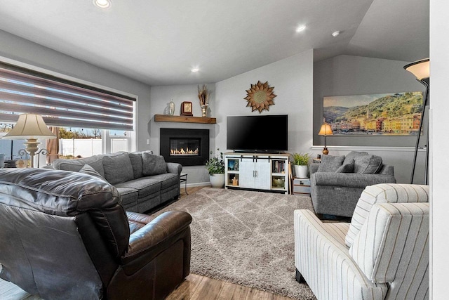 1397 Lear Ln, De Pere, WI 54115 - living area with wood finished floors, a warm lit fireplace, recessed lighting, and lofted ceiling
