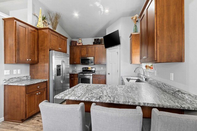 1397 Lear Ln, De Pere, WI 54115 - kitchen featuring appliances with stainless steel finishes, a sink, a peninsula, a breakfast bar area, and light wood-style floors
