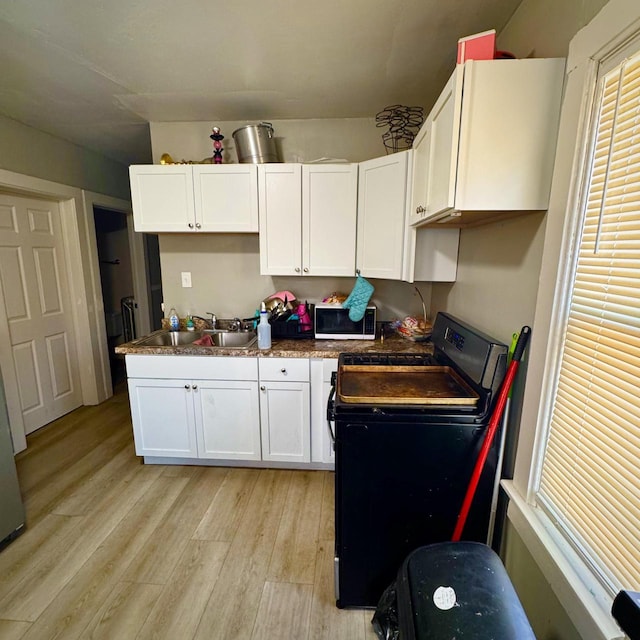 2664 N Booth St, Milwaukee, WI 53212 - kitchen featuring range with electric stovetop, a sink, light wood-type flooring, and white cabinets